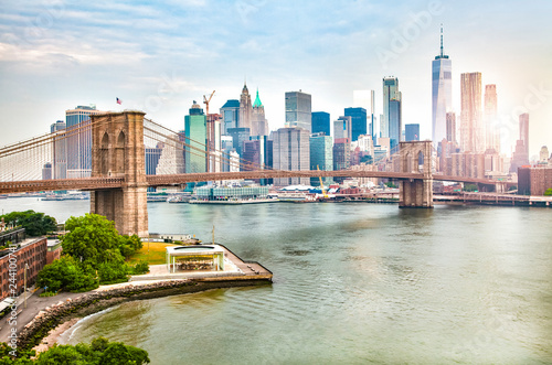 Amazing panorama view of New York city skyline and Brooklyn bridge with skyscrapers and East River flowing during daytime in United States of America © Stefan
