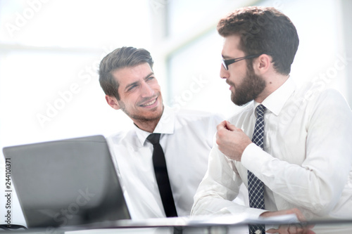two business colleagues are discussing something sitting at the Desk