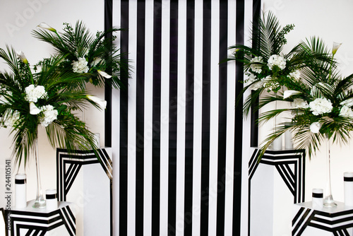 two vases with flowers on a black and white striped background