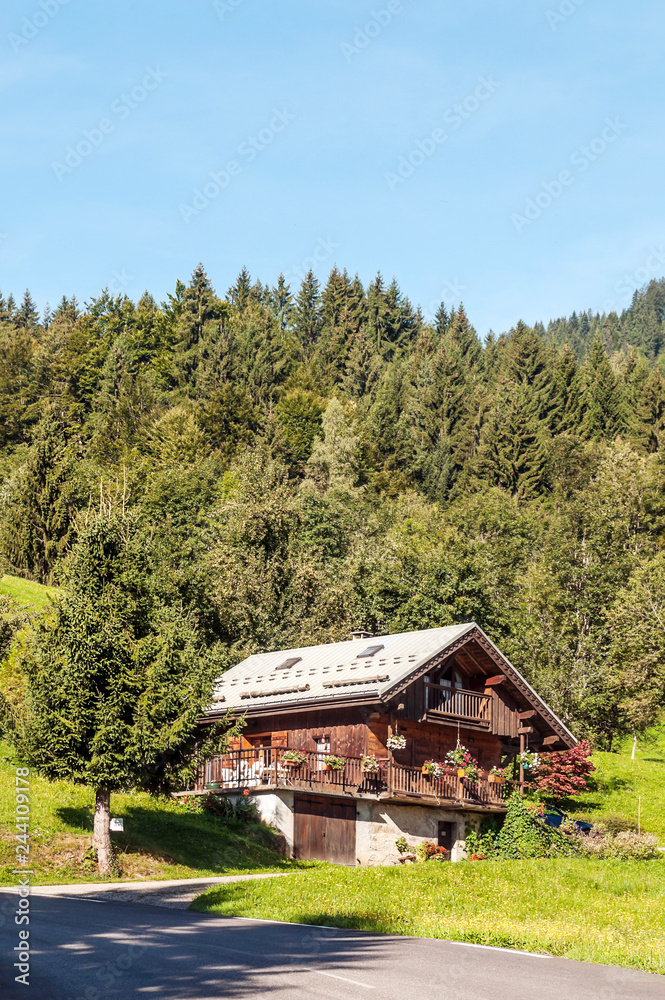 Cottage located on top of a hill in the French Alps on a sunny day.