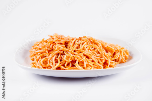 Spaghetti with pesto on a plate on a white background