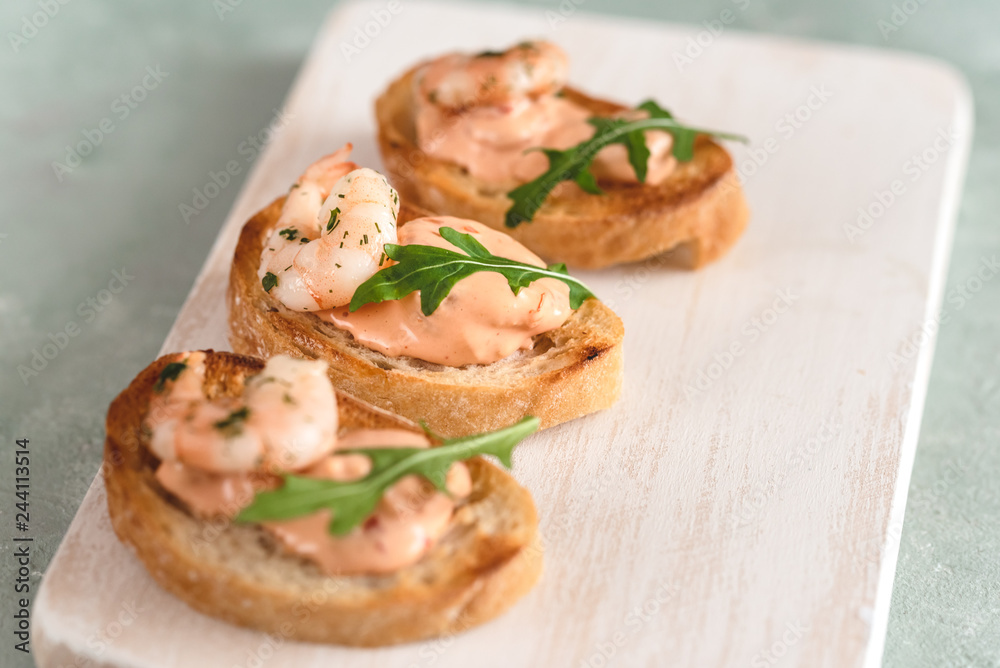 Bruschetta sandwiches with shrimps, creamy sauce and rocket salad.