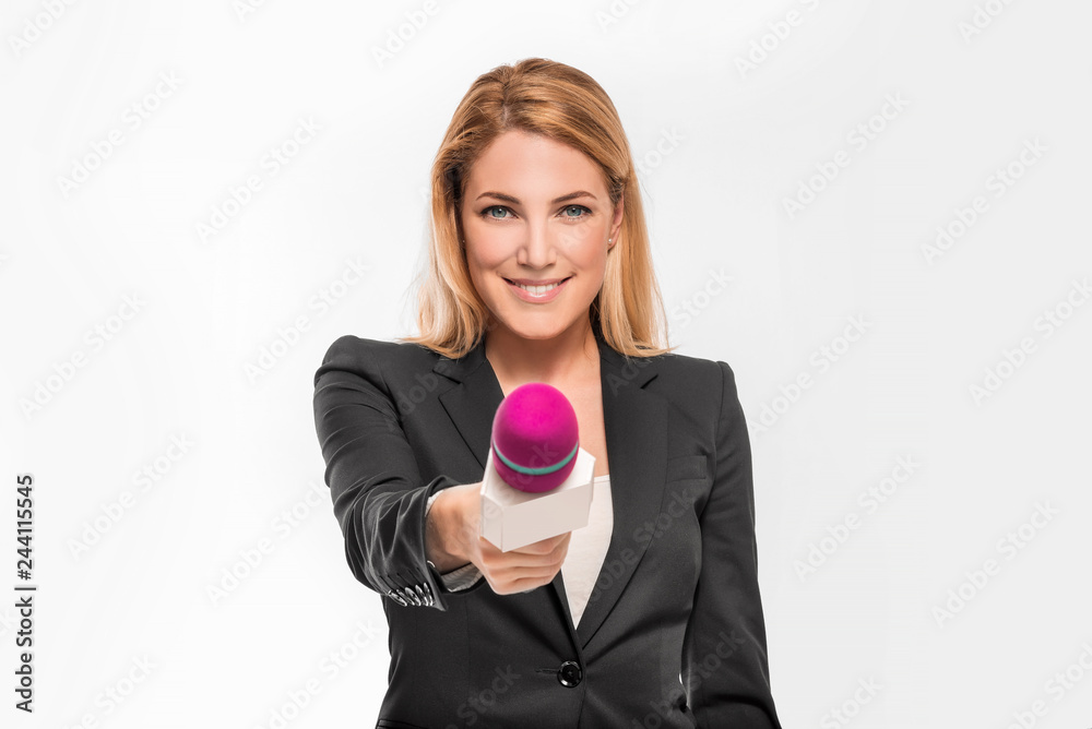 Attractive blonde TV presenter on white background holding a microphone and points to an object. Attractive blonde TV presenter on white background holding a microphone and points to an object.