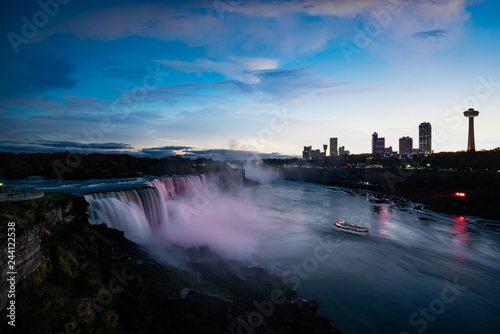 Niagara falls lit at night by colorful lights