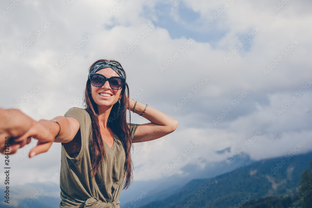 Beautiful happy young woman in mountains in the background of fog Beautiful happy young woman in mountains in the background of fog