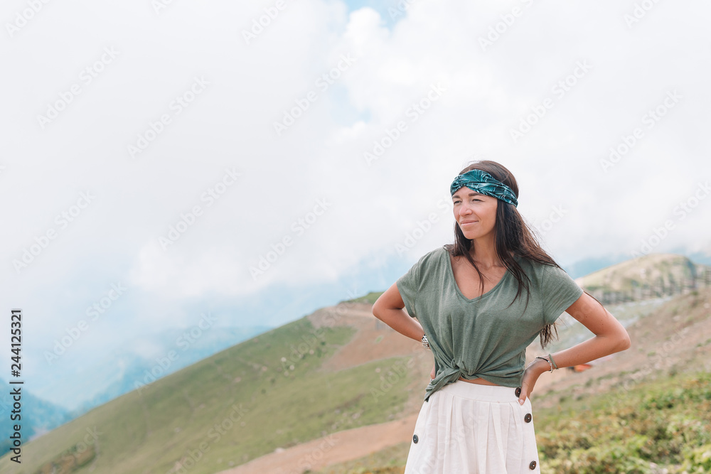 Beautiful happy young woman in mountains in the background of fog Beautiful happy young woman in mountains in the background of fog