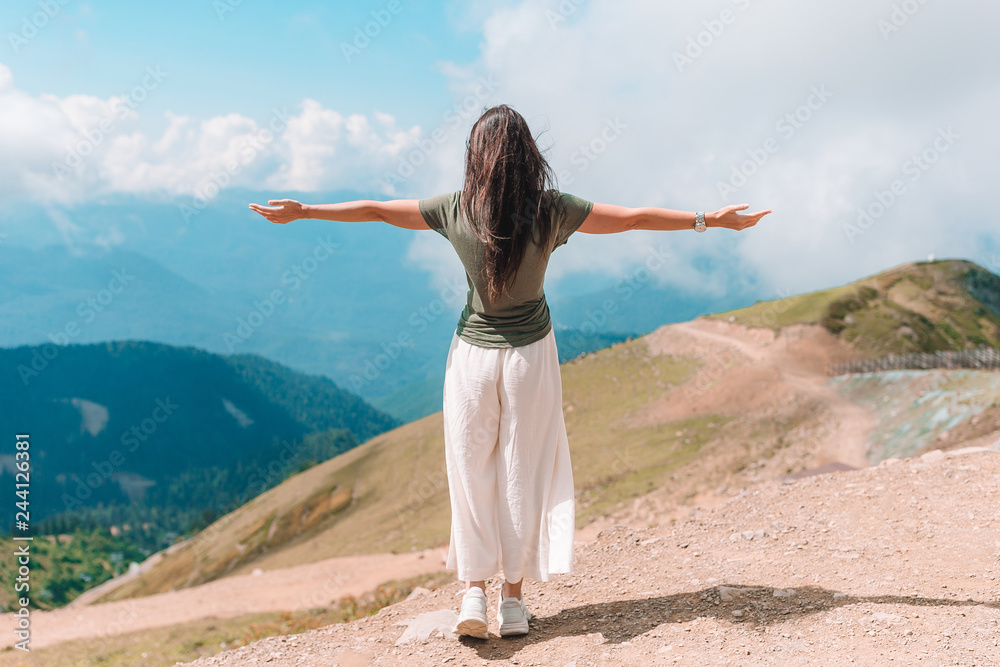 Beautiful happy young woman in mountains in the background of fog Beautiful happy young woman in mountains in the background of fog