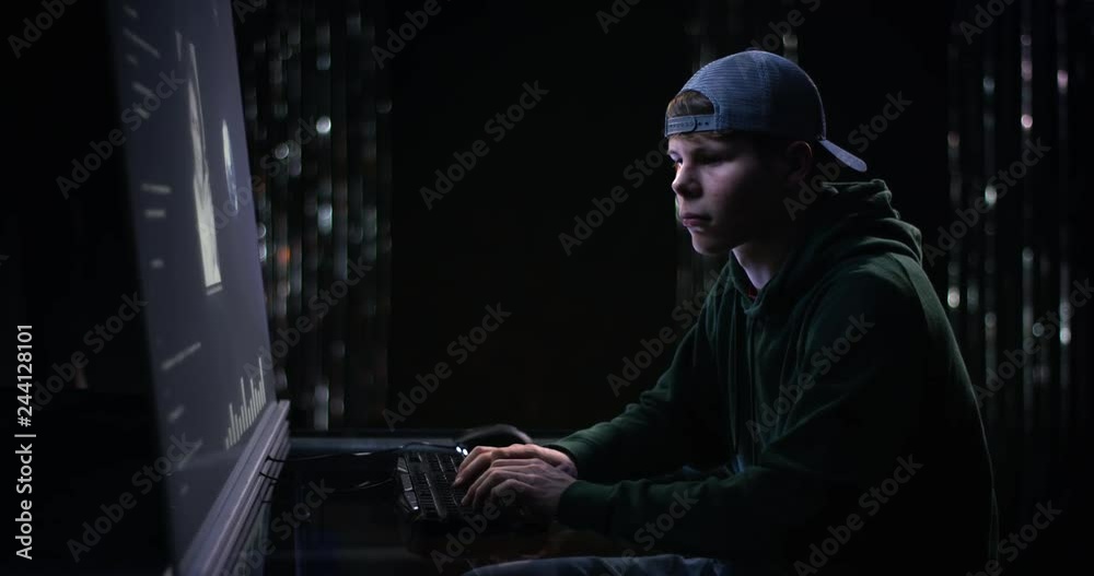 Young man sitting at hightech screen hacking Young man sitting at hightech screen hacking