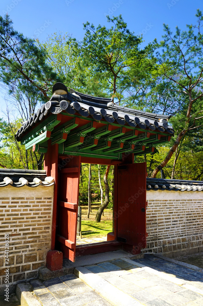 Seoul, South Korea - April 2018: Wooden gate and stone wall in Jongmyo Shrine. Seoul, South Korea - April 2018: Wooden gate and stone wall in Jongmyo Shrine.