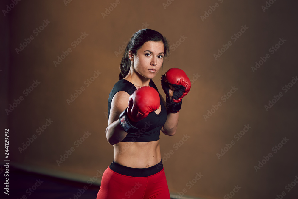 Young athletic girl fighter trains in the gym.