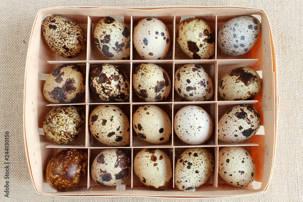 Quail eggs in a wooden box on a rough linen cloth Quail eggs in a wooden box on a rough linen cloth