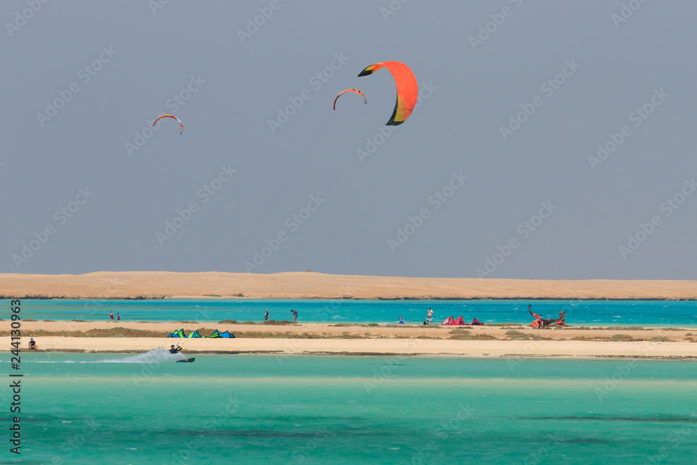 Recreational activity, water sports, action, hobby and fun in summer time. Kite boarding sport, kiting people on island, blue sea water, sandy beach, kites in sky. Seaside view scenery, vacation rest Recreational activity, water sports, action, hobby and fun in summer time. Kite boarding sport, kiting people on island, blue sea water, sandy beach, kites in sky. Seaside view scenery, vacation rest