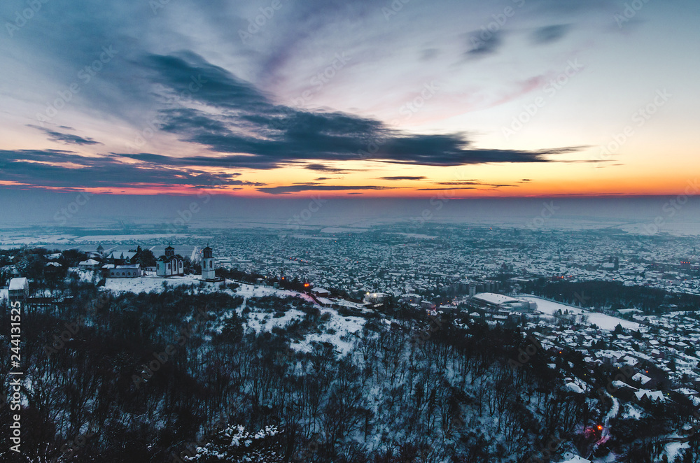 View on a city under the colorful sky on a winter sunny day. Vrsac, Serbia.