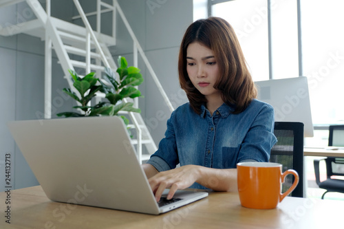 Young asian woman in casual style using laptop computer at home office background , people and technology, working at home, lifestyles