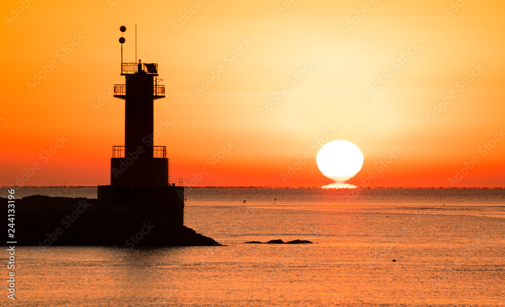 등대 너머에서 떠오르는 태양