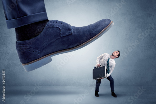 Big foot trying to crush small man who is afraid of that
