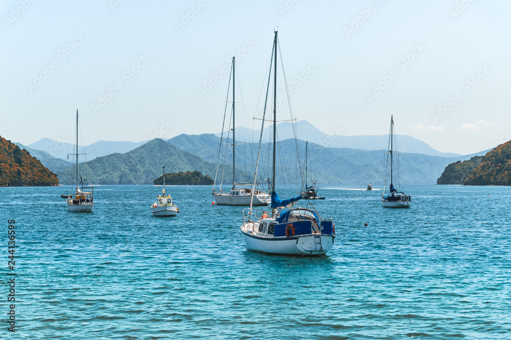 Beautiful bay with yachts and boats. Blue sea, blue sky, and mountains for background. Picton, South Island New Zealand Beautiful bay with yachts and boats. Blue sea, blue sky, and mountains for background. Picton, South Island New Zealand