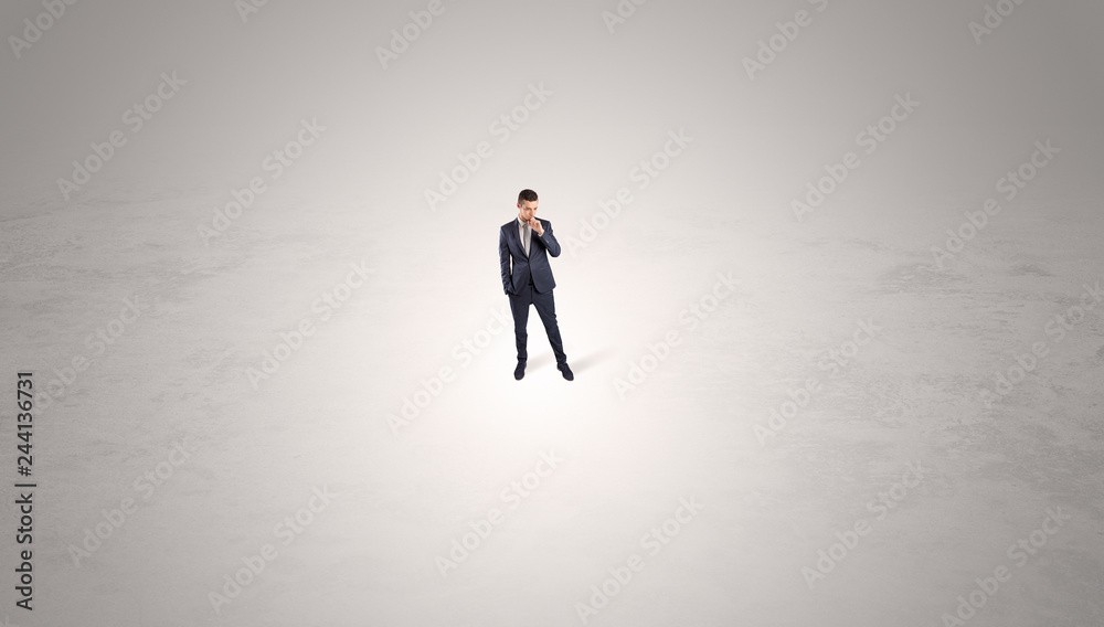 Young businessman standing alone in the middle of an empty space
Young businessman standing alone in the middle of an empty space