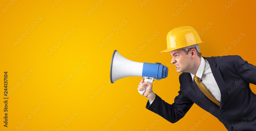 Young architect constructor yelling with megaphone and copyspace Young architect constructor yelling with megaphone and copyspace