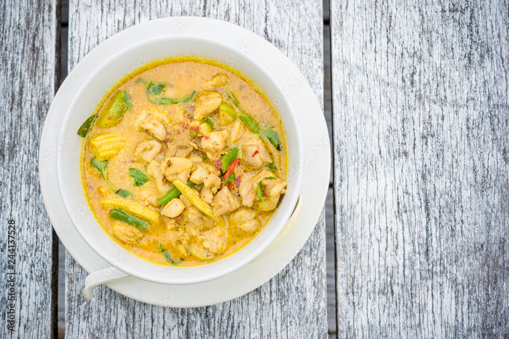 delicious yellow Thai curry on a wooden table