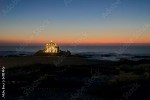 Landscape over the beach of miramar with view to chapel of senhor da Pedra at blue hour