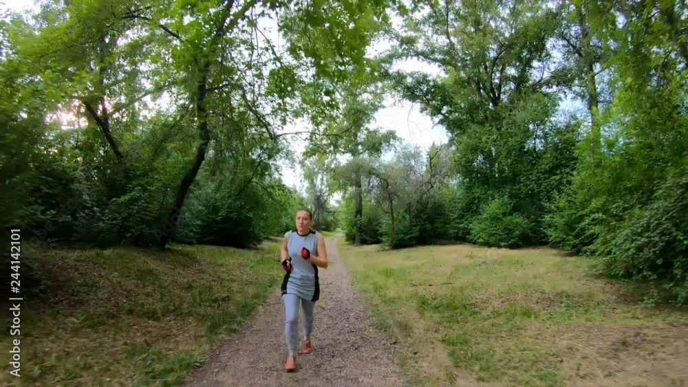 Jogging in the park. Girl running along the forest path. Front view. Slow motion Jogging in the park. Girl running along the forest path. Front view. Slow motion