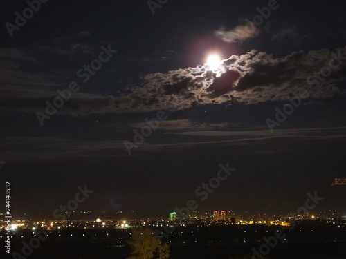 City at night with moon on sky