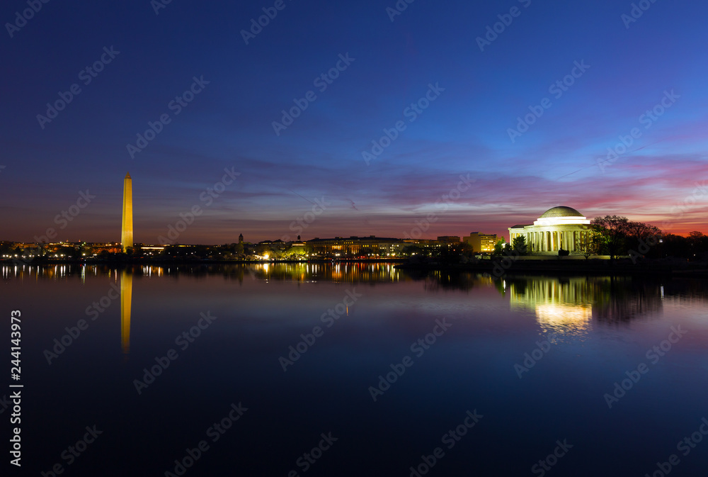 Washington DC panorama around Tidal Basin at dawn during cherry blossom in spring. Urban skyline with Thomas Jefferson Memorial and Washington Monument in US capital.
