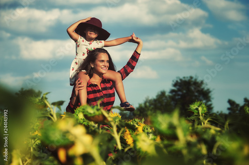 Картината върху платно Mom and daughter in the field with sunflowers