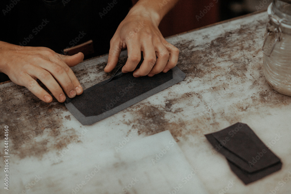 Close up of leather craftsman working with natural leather. Handmade master at work in local workshop. Handmade concept. Close up of leather craftsman working with natural leather. Handmade master at work in local workshop. Handmade concept.