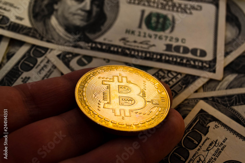 Golden bitcoin coins on a paper dollars