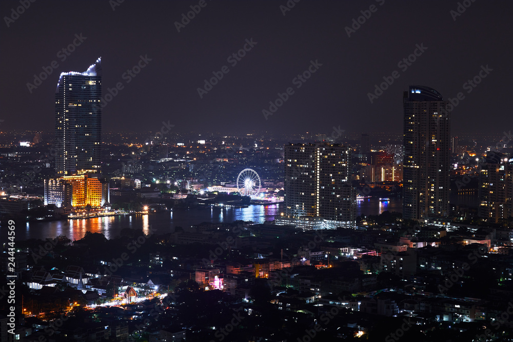 night cityscape with building and landmark of swing near river