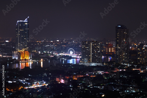 night cityscape with building and landmark of swing near river