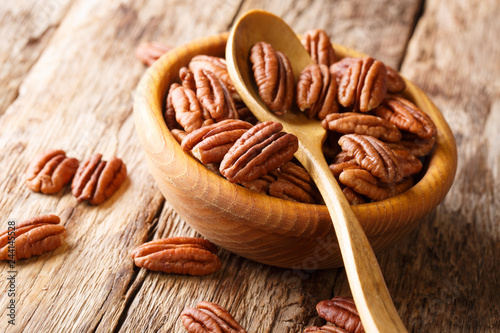 Halves of pecans in a bowl on a wooden table. horizontal, rustic