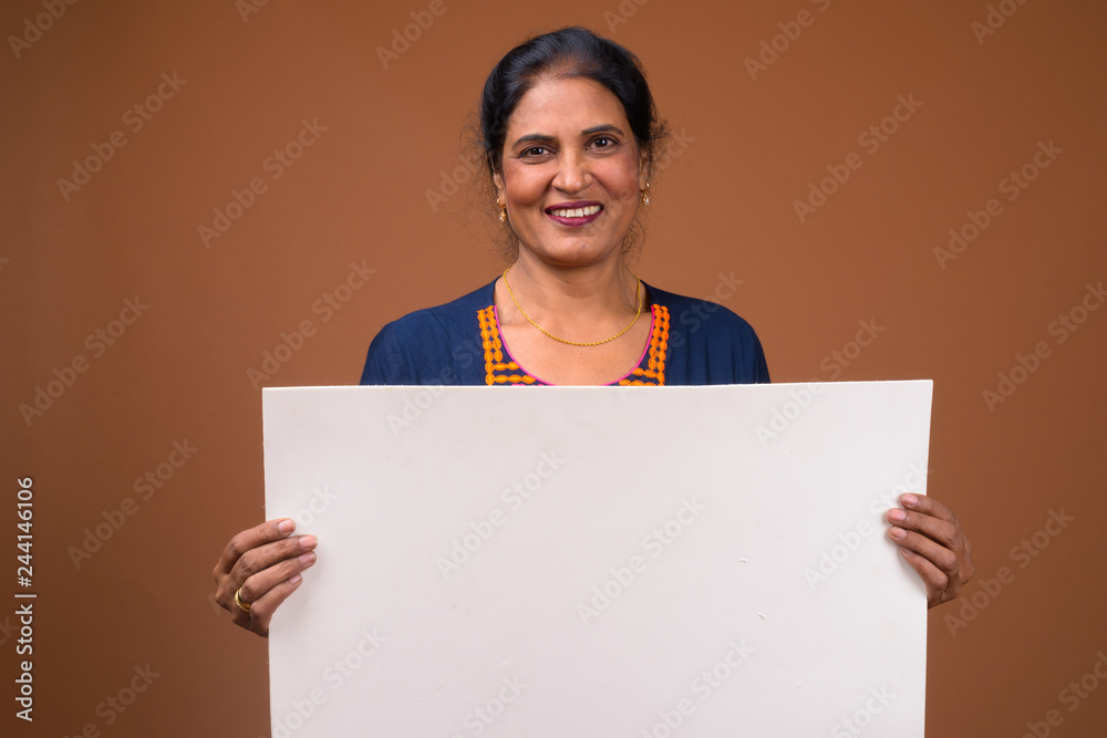 Happy Indian woman holding empty white board with copyspace Happy Indian woman holding empty white board with copyspace
