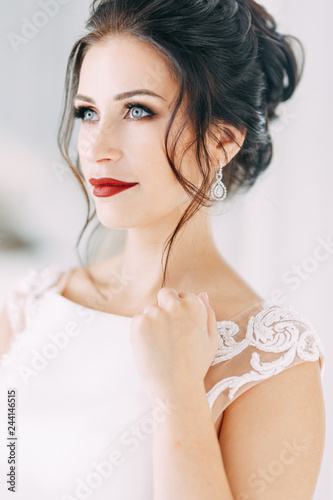 Beautiful girl in a wedding dress with a bouquet. Bride in a bright Sunny Studio.