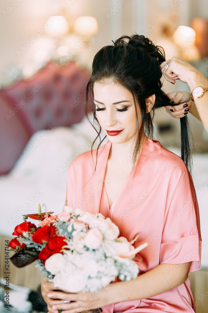 Bride's fees in a negligee in a luxury hotel. Boudoir dress and bouquet at the wedding. Bride's fees in a negligee in a luxury hotel. Boudoir dress and bouquet at the wedding.