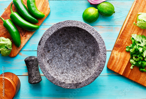 empty molcajete on table with ingredients ready to prep photo