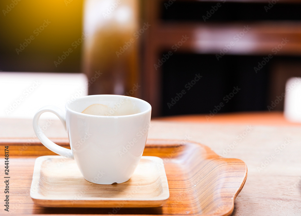 Hot coffee in a white cup on a wooden table.