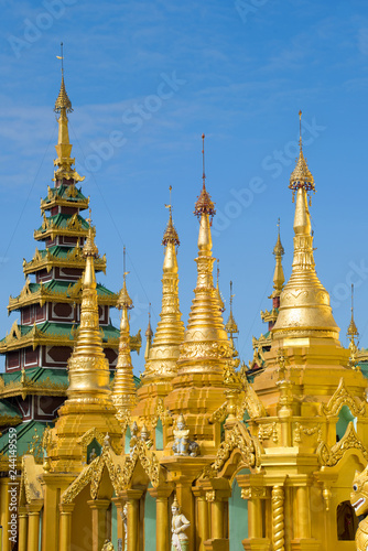 Golden stupas against the blue sky. Fragment of the Shwedagon temple complex