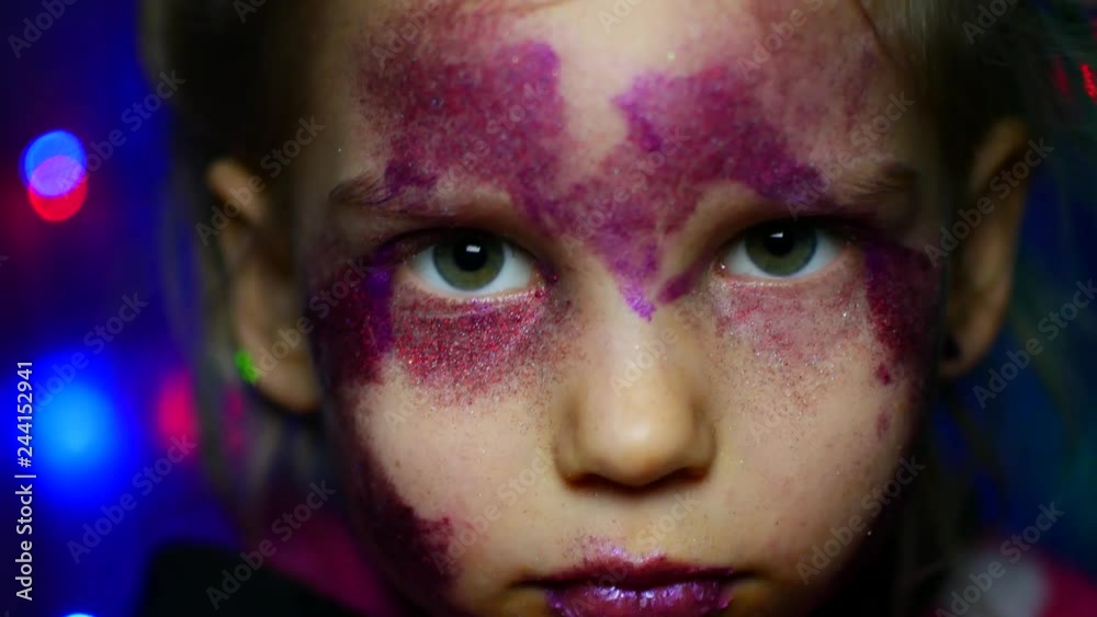 Five-year girl on the background of festive garlands. Makeup, glitter, portrait Five-year girl on the background of festive garlands. Makeup, glitter, portrait