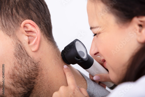 Doctor Checking Skin On Man's Neck