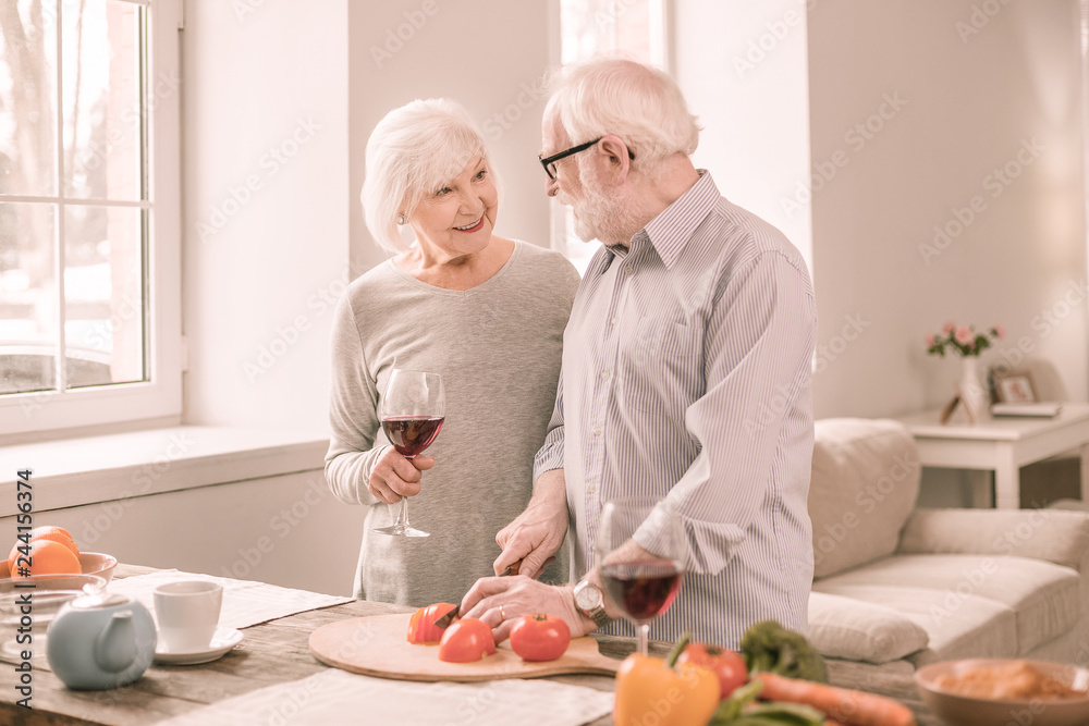 Cheerful mature male person cooking salad for lunch Cheerful mature male person cooking salad for lunch