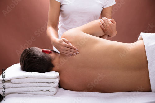 Therapist Giving Shoulder Massage To Man