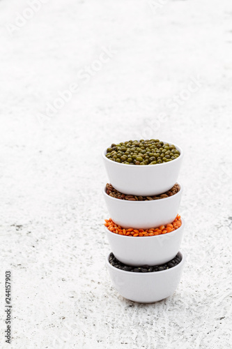 Various assortment set of indian legumes in white melamine bowls on white background with copyspace. photo