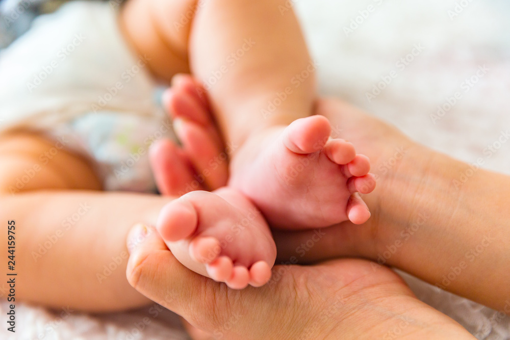Mother holding the baby's feet Mother holding the baby's feet