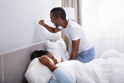 Irritated African Couple Disturbed By Noise On Bed