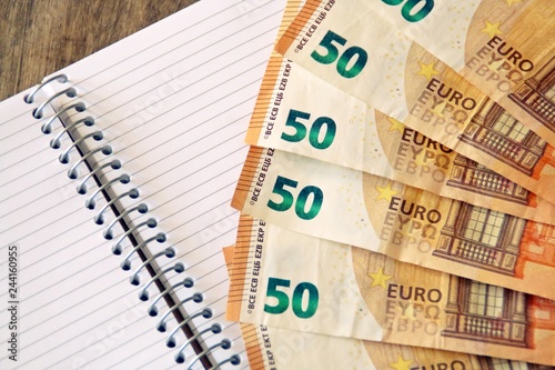 Finanzas, cuentas y economía. Billetes de 50€, cuaderno y bolígrafo.