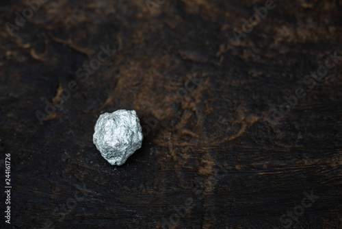 lump of silver or platinum on dark wood background