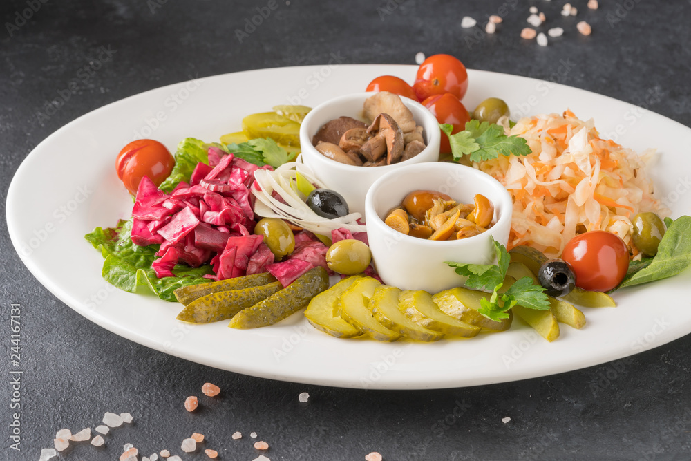 Pickled vegetables in a white plate on gray background Pickled vegetables in a white plate on gray background